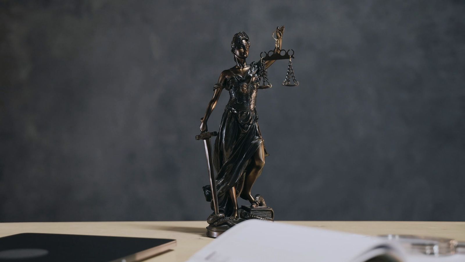 Lady Justice on a desk with an open diary and documents