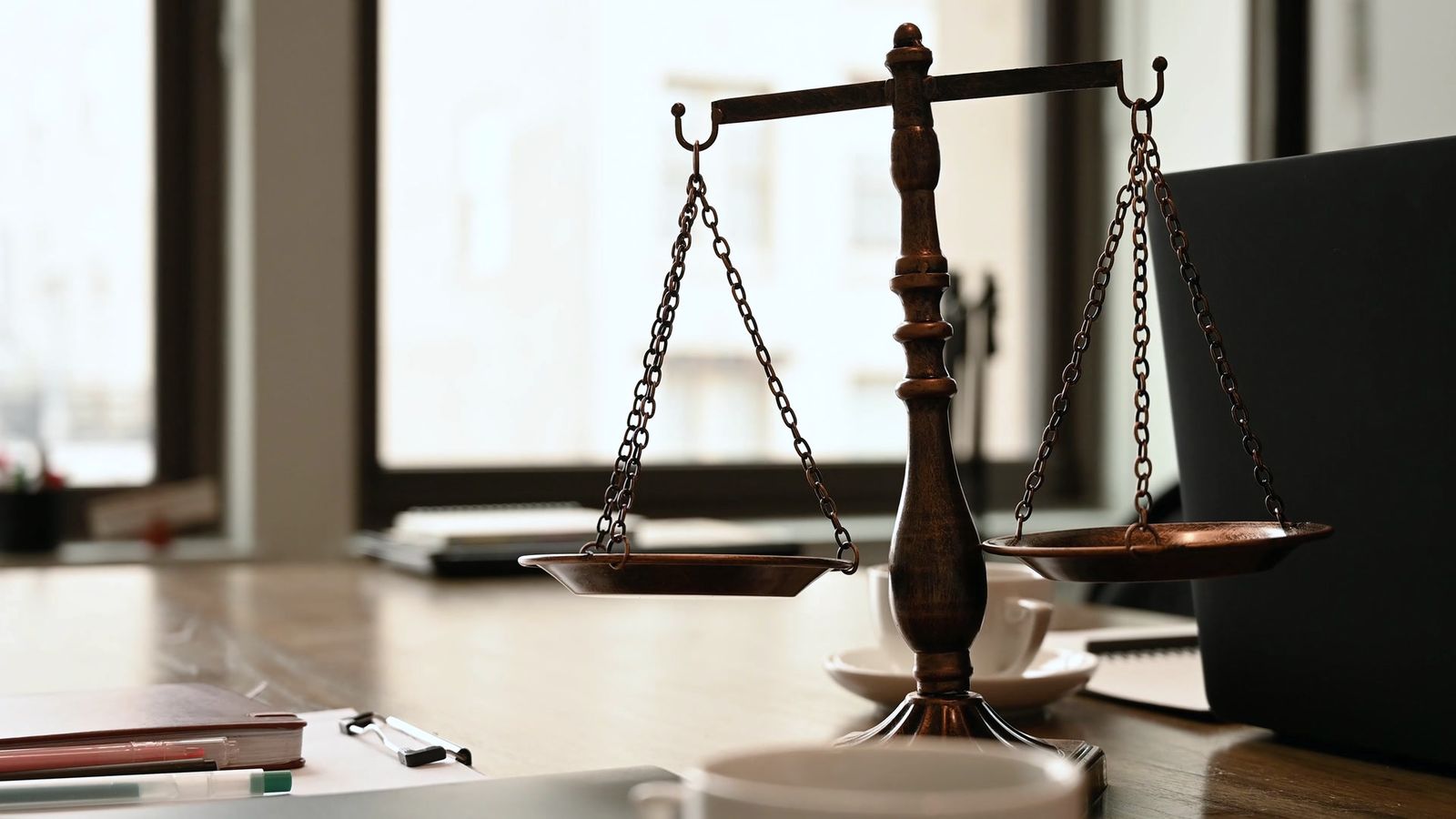 Scales of justice on a desk in a bright law office