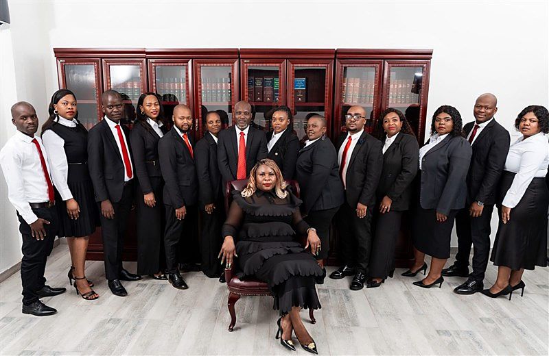 The Ngomana & Associates team with Director Fortunate Nwa-khosa Ngomana seated, in front of mahogany law-book cabinets